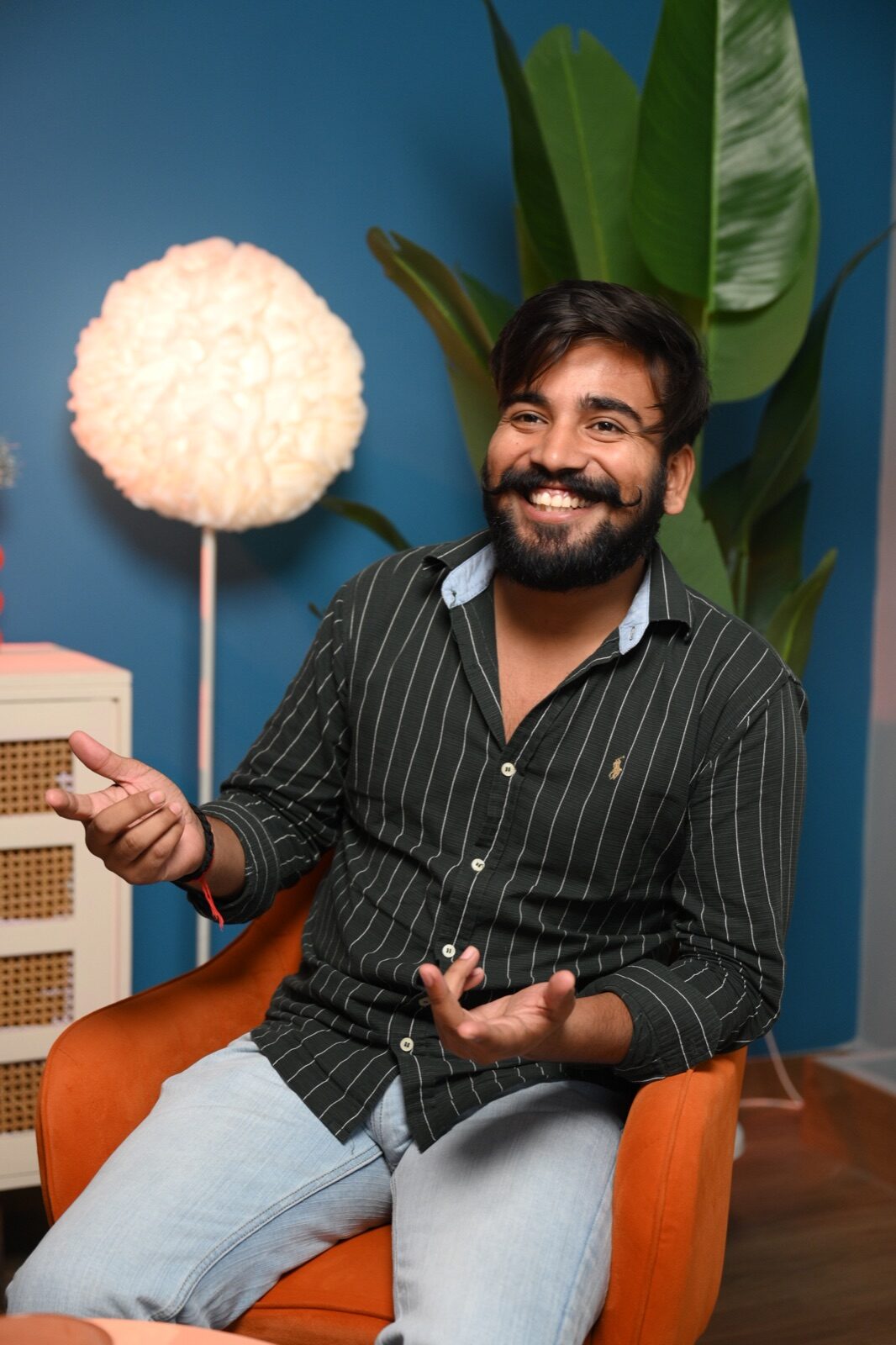 Podcast guest speaking on a styled blue studio set with controlled lighting