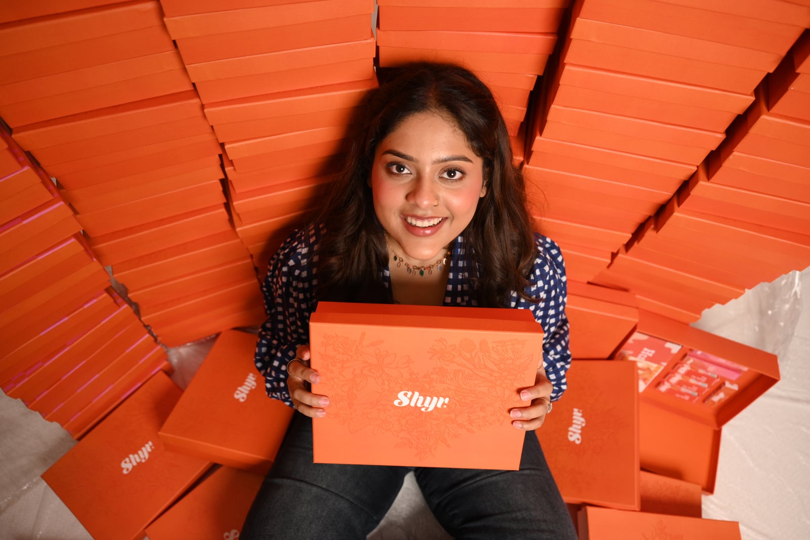 Overhead portrait surrounded by orange Rakhi gift boxes