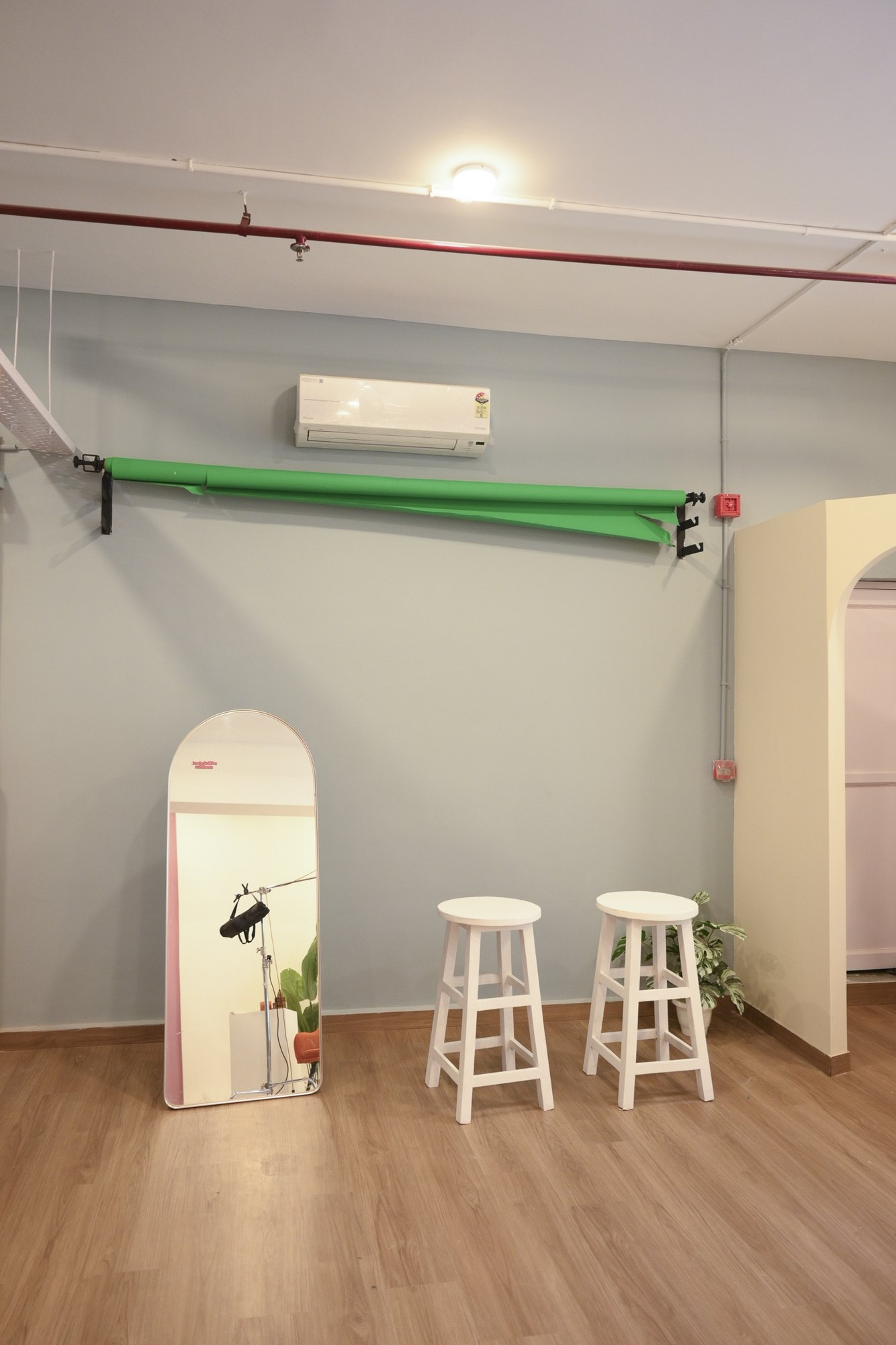 Installed green paper backdrop roll above a floor mirror and studio stools