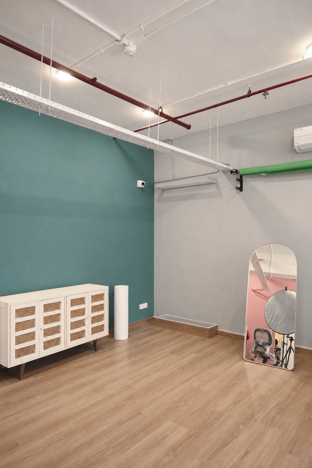 Teal and grey studio walls shown together with furniture and a floor mirror