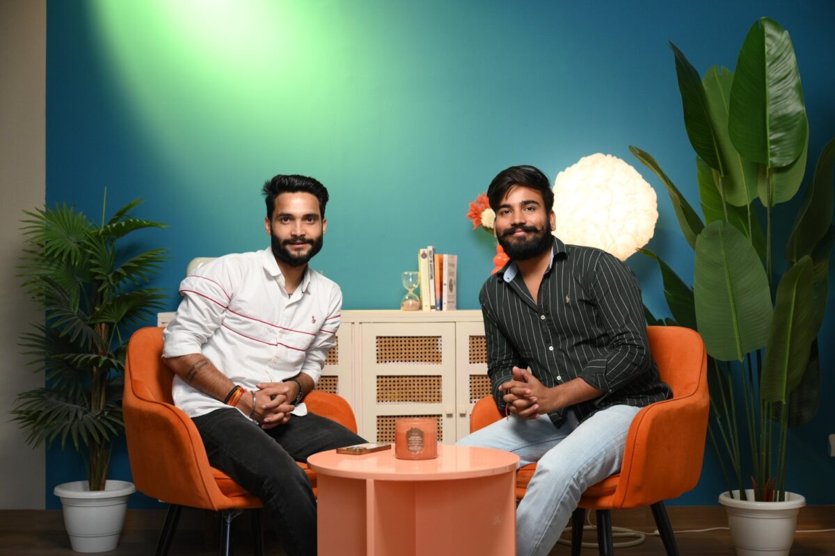Two people seated on a controlled blue studio set for brand video production at Sooper Studios in Noida