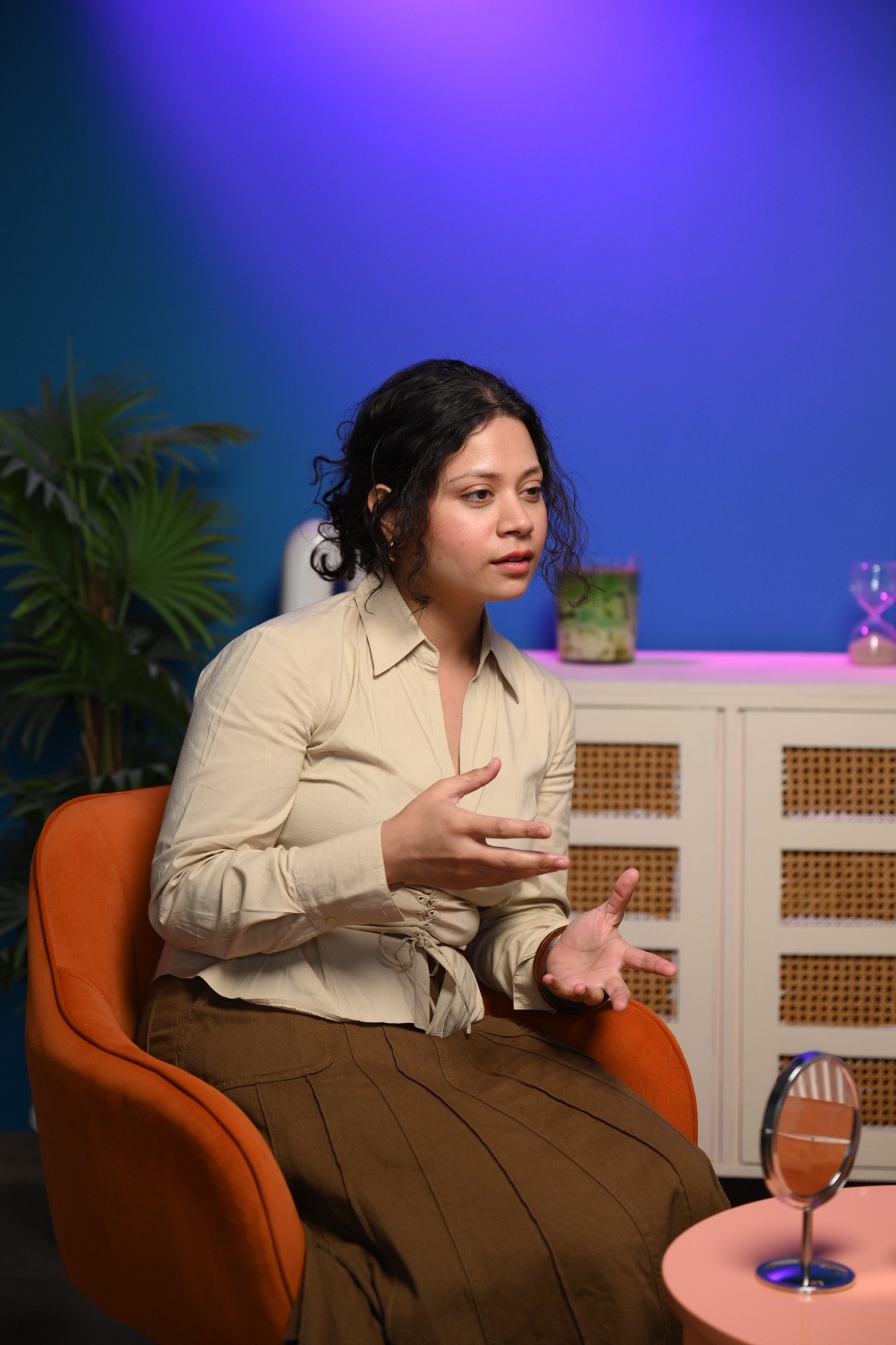 Single interview subject framed vertically on a controlled blue studio set