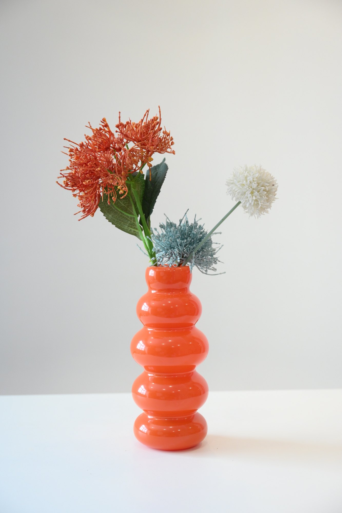 Orange sculptural vase and florals
