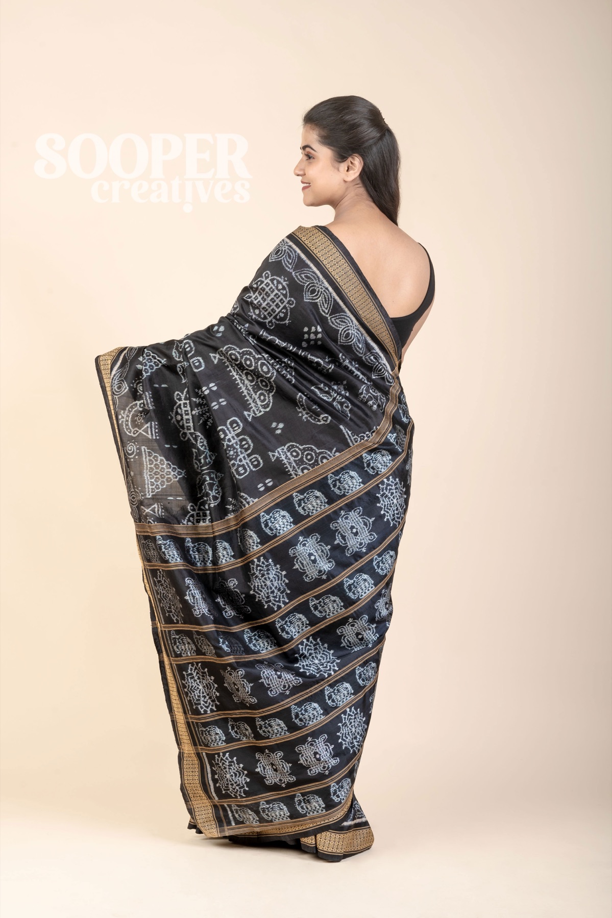 Fashion model displaying a black saree on a controlled neutral studio background for a Delhi NCR lookbook