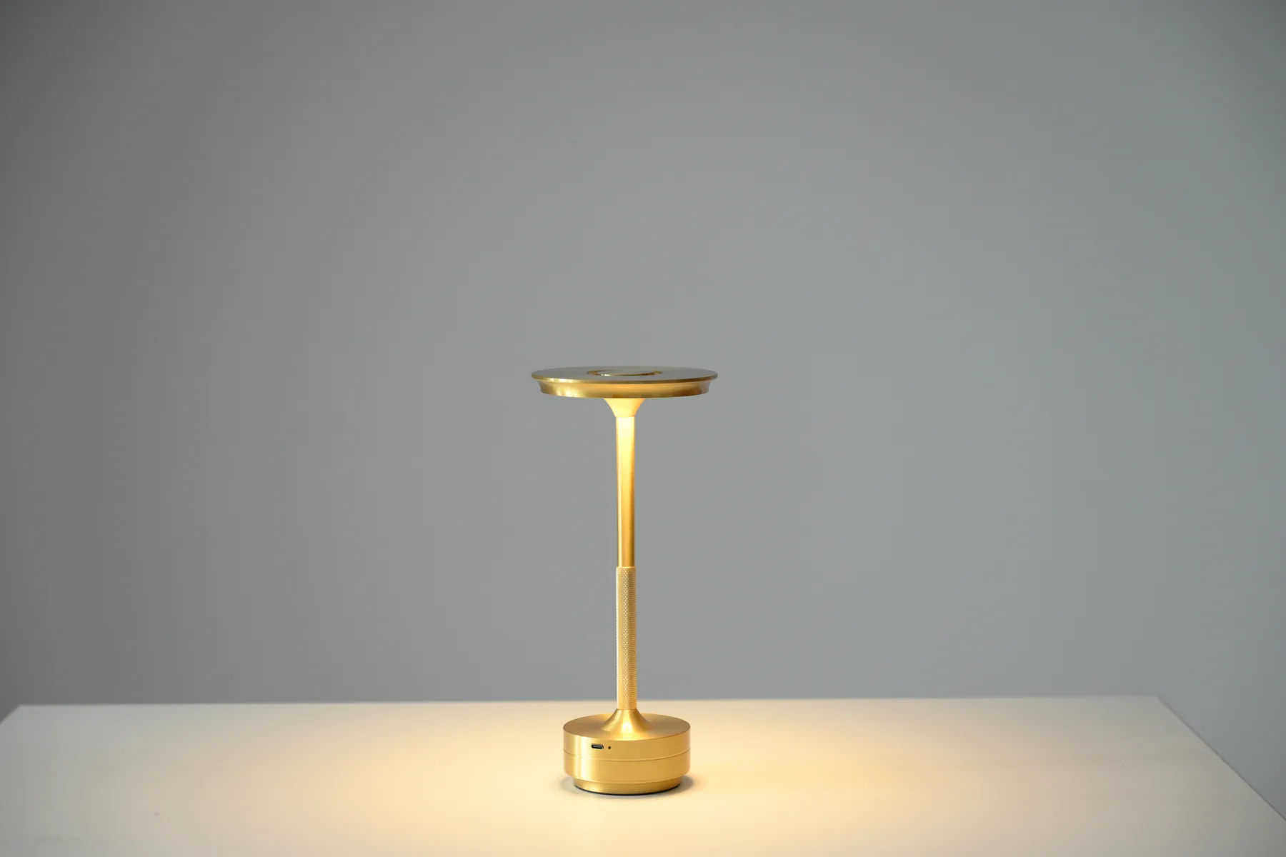 Slim gold rechargeable table lamp available as a studio prop
