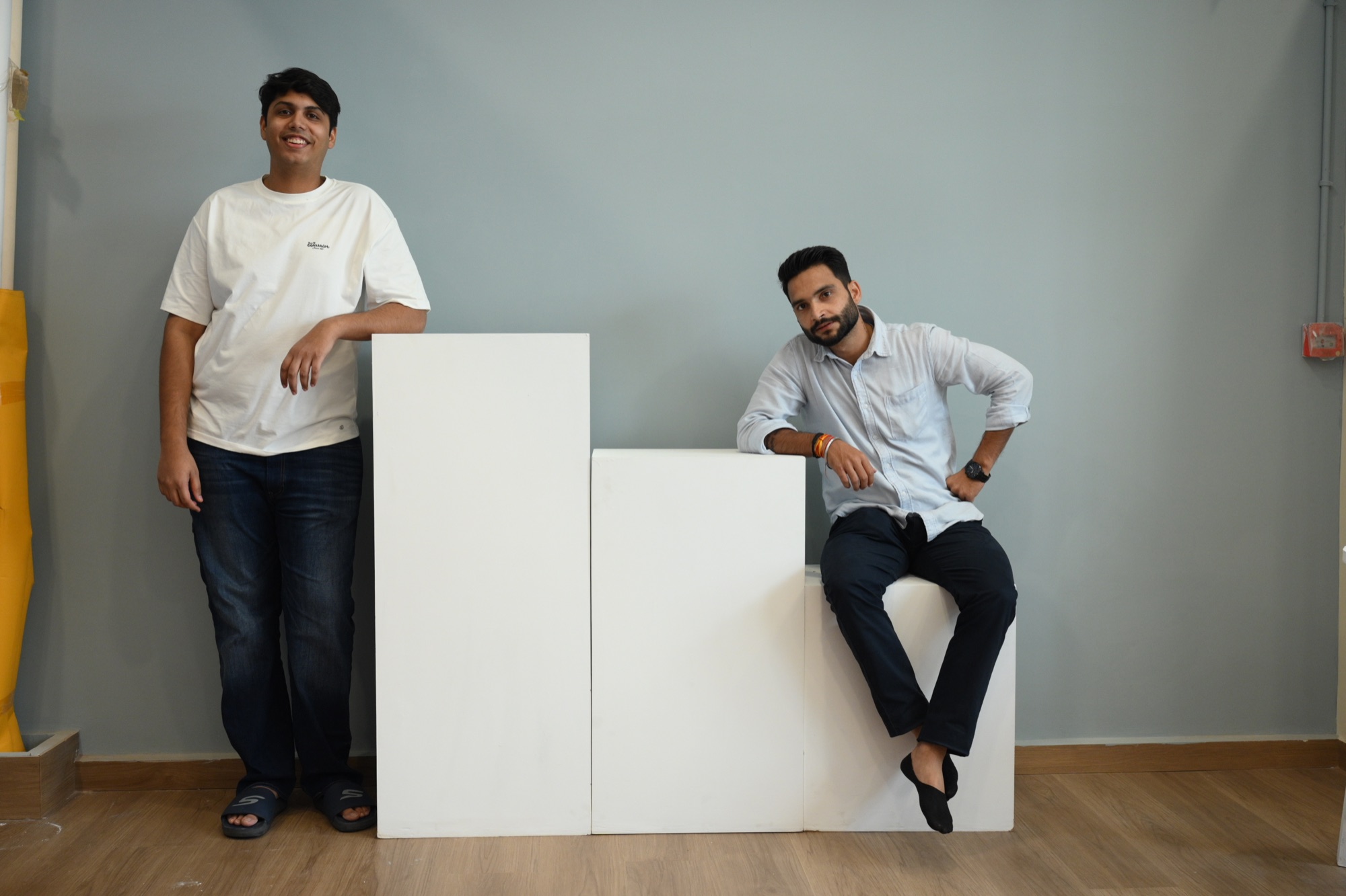 Two Sooper Studios team members beside white product plinths in the Noida studio